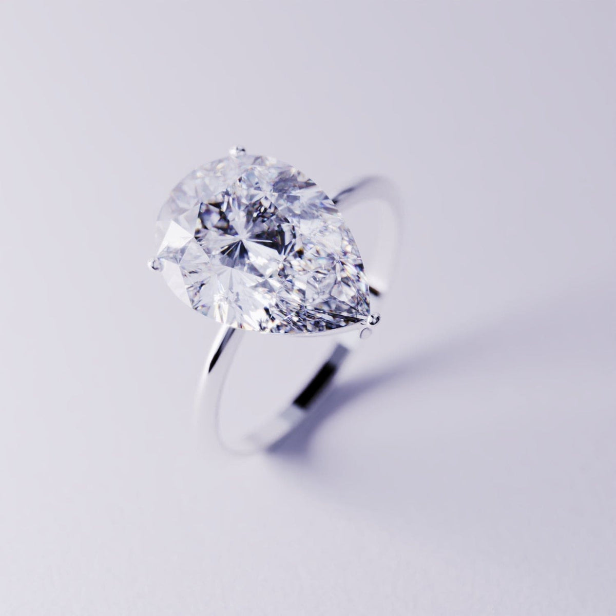 Silver-toned ring with a large pear-cut clear gemstone on a thin band.