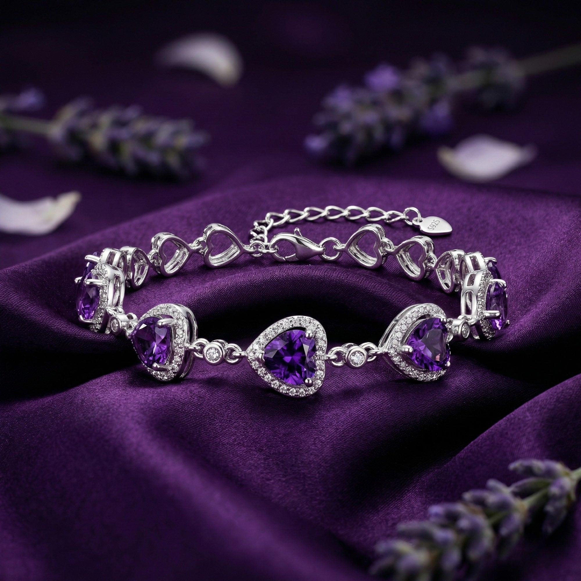 Sterling silver heart amethyst bracelet with halo settings on a purple silk background with lavender.