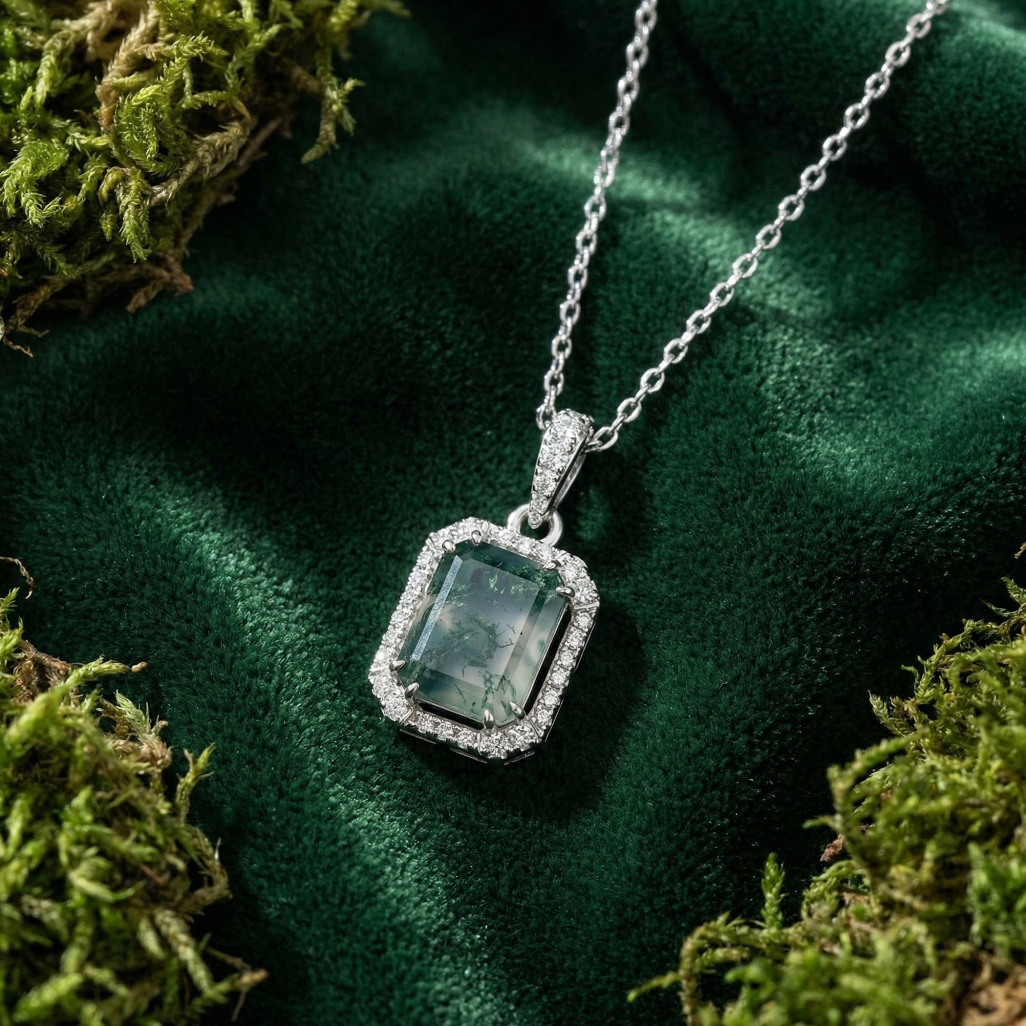 Rectangular moss agate pendant necklace in S925 sterling silver on green velvet and moss lifestyle background.