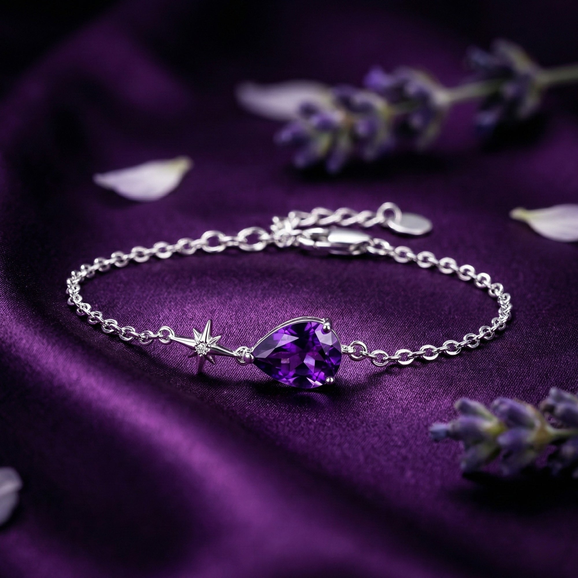 Pear cut amethyst bracelet in S925 sterling silver with a star charm on purple silk fabric.