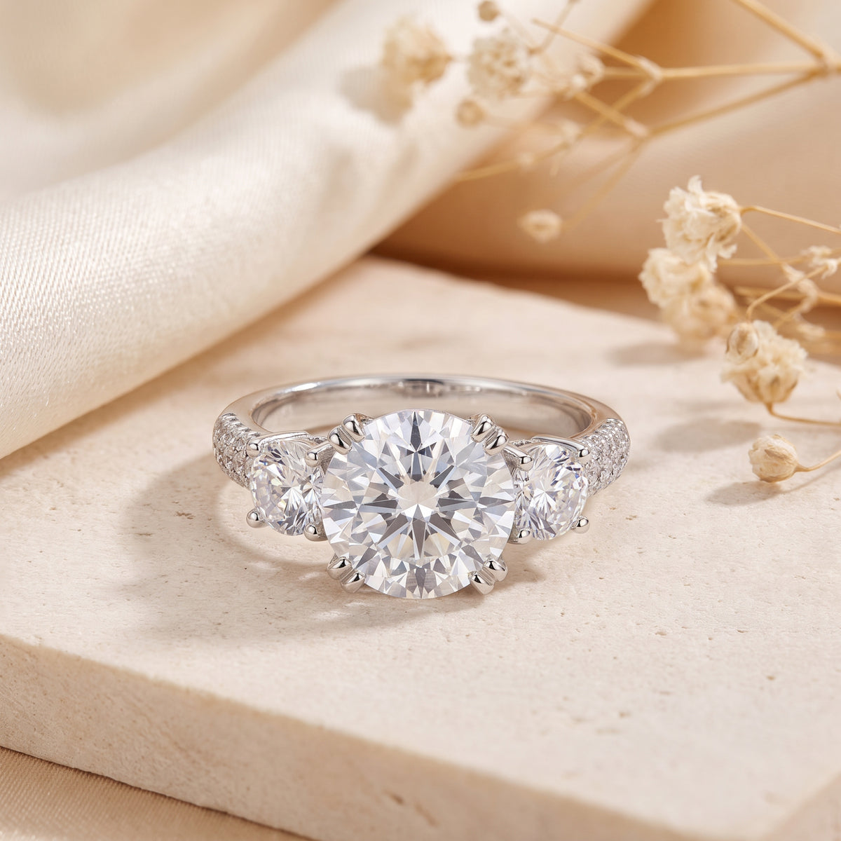 Front view of the silver three-stone ring with a large round center stone and pave-set accents.