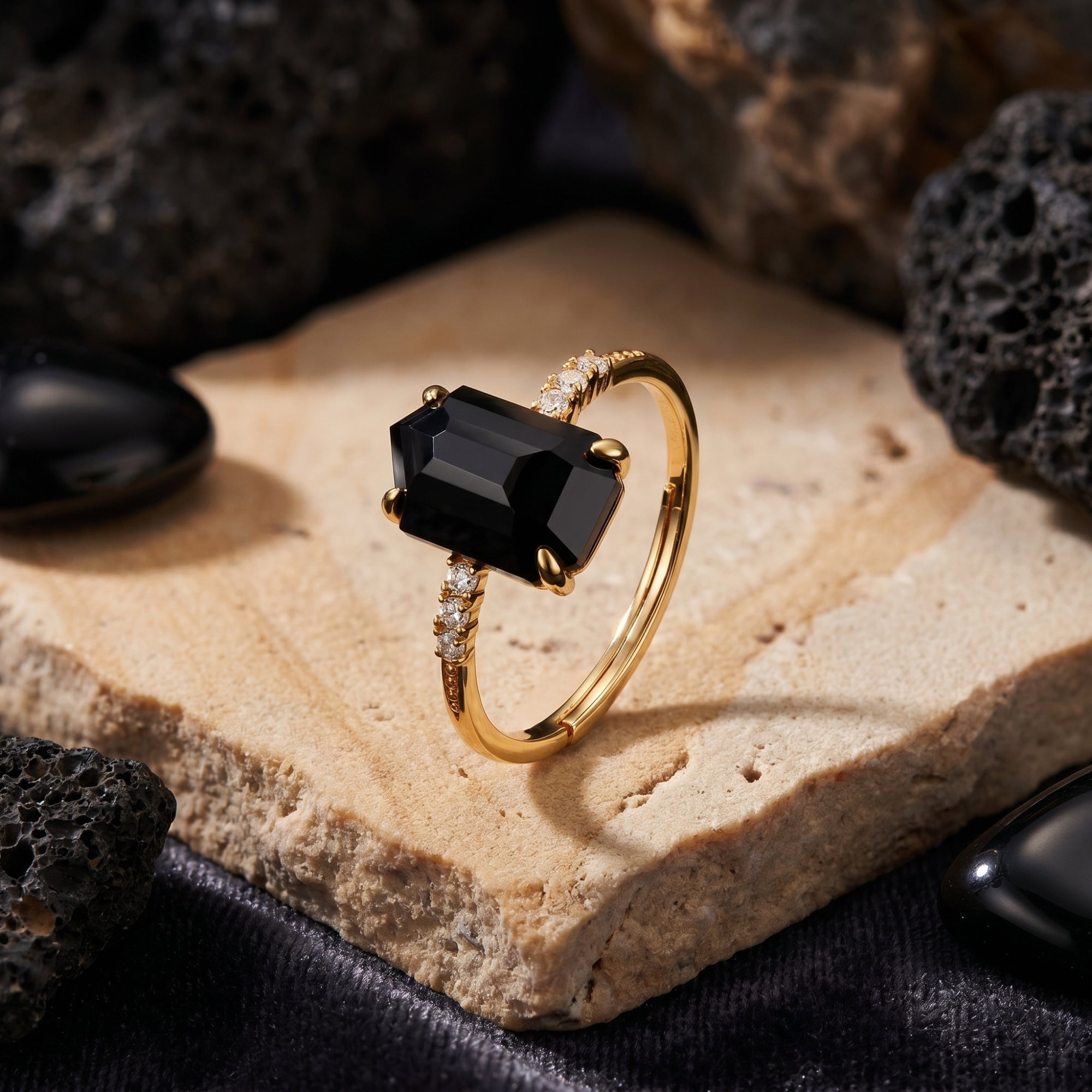 Noctura statement ring with irregular-cut natural onyx and zircon accents in 18K gold vermeil on a stone background.