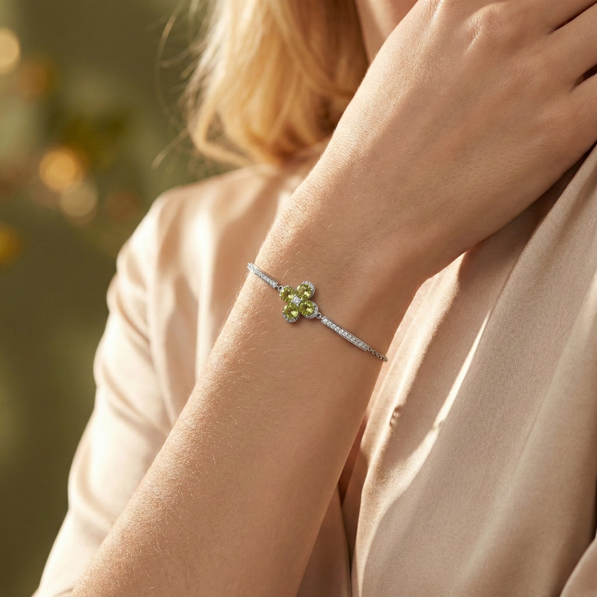 Woman wearing the Lymara station bracelet in S925 sterling silver with vibrant green peridot stones on her wrist.
