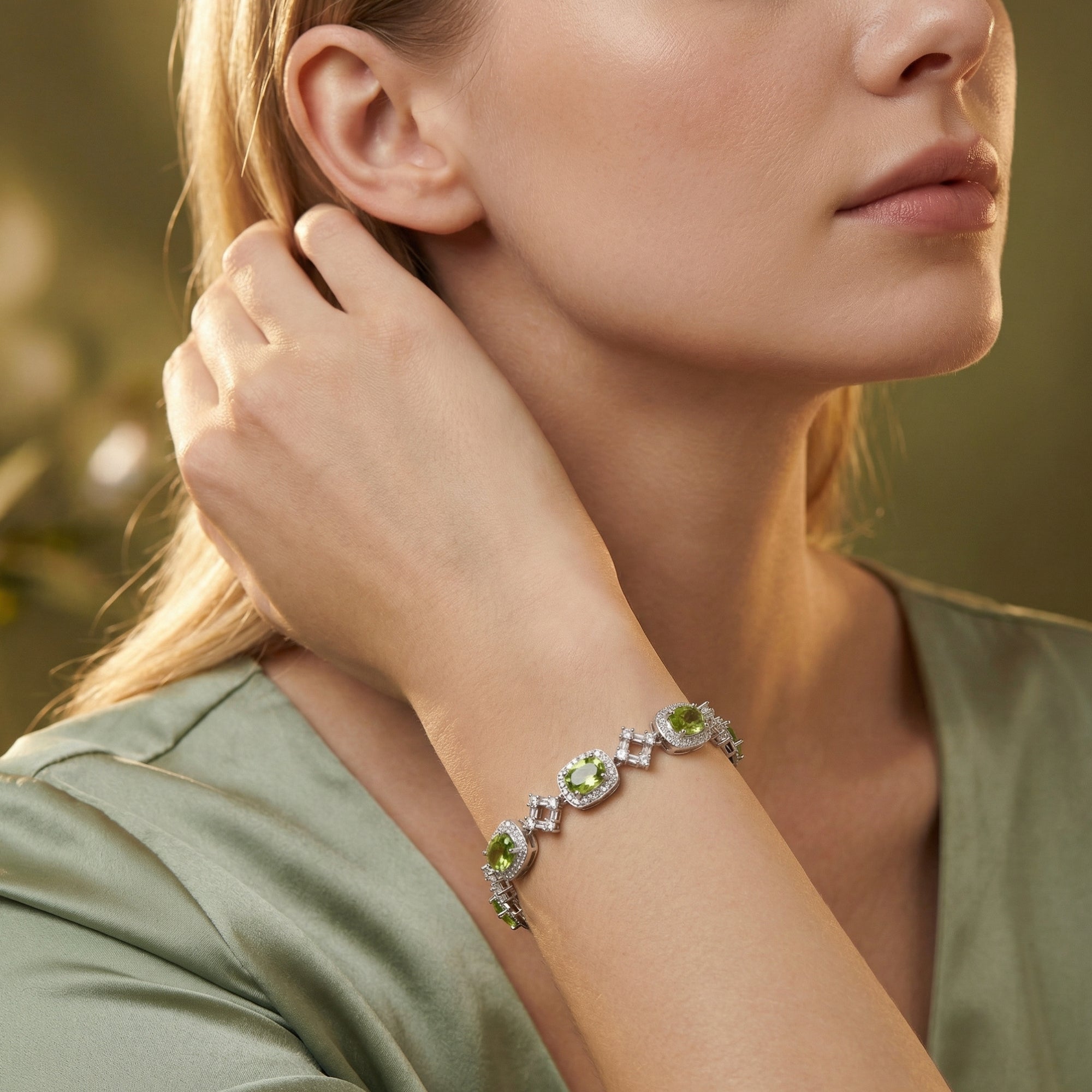Model wearing the Orinthia station bracelet featuring oval cut peridot and sterling silver on her wrist.