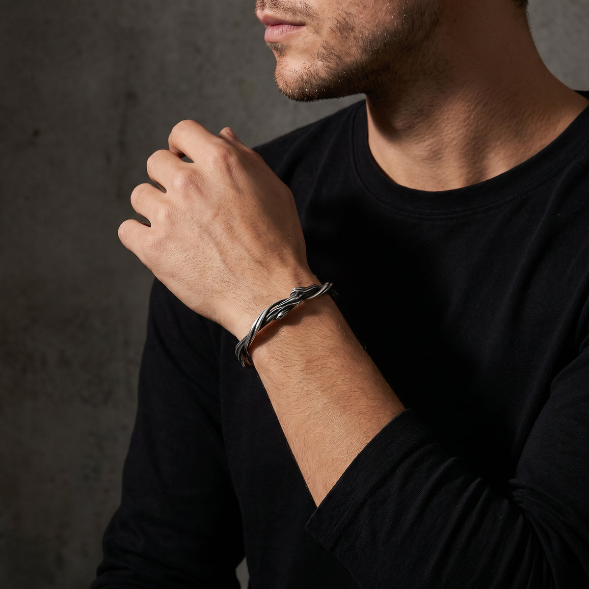 Man wearing the silver twisted vine cuff bracelet with a black long-sleeve shirt.