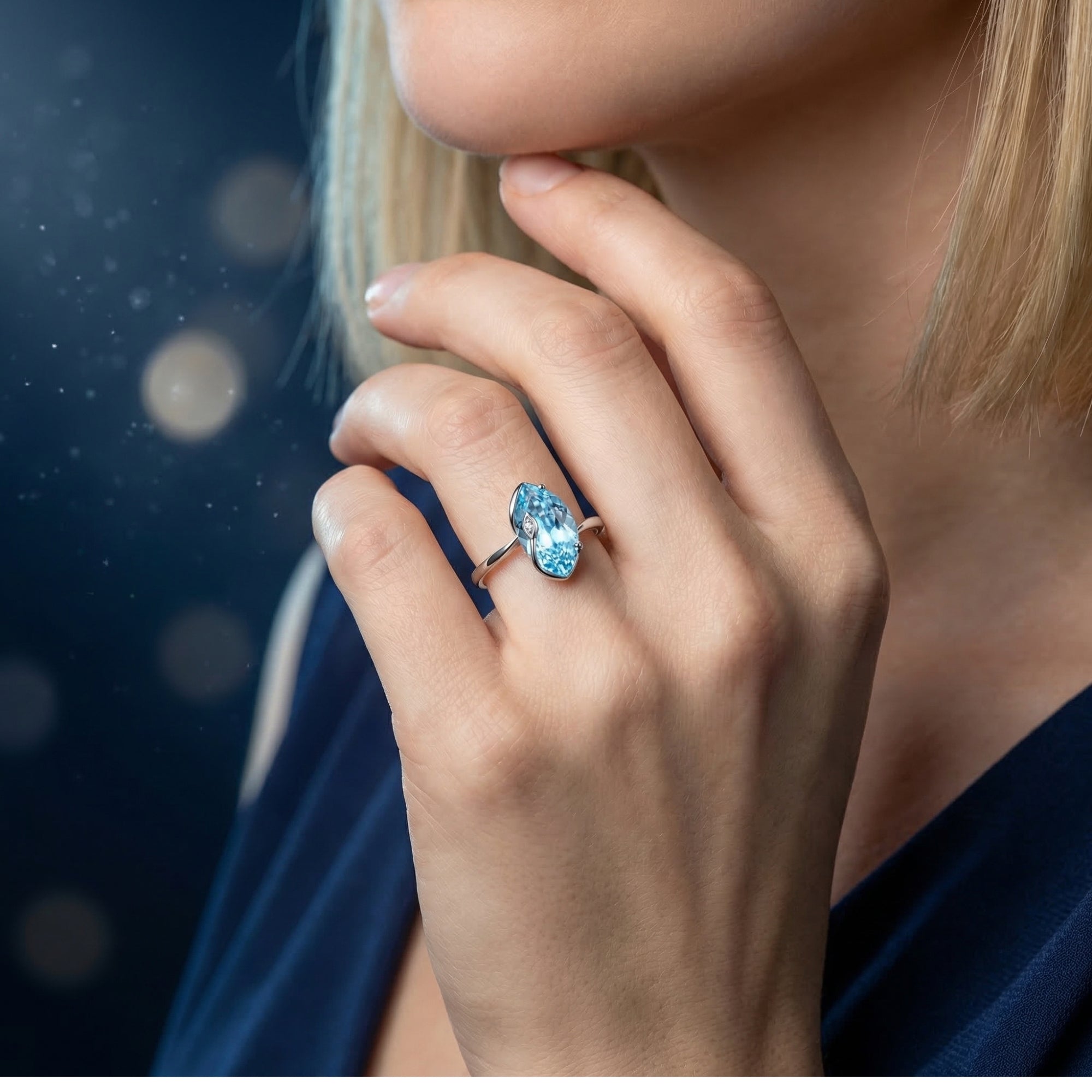 Marquise cut natural blue topaz sterling silver ring worn on a woman's hand.