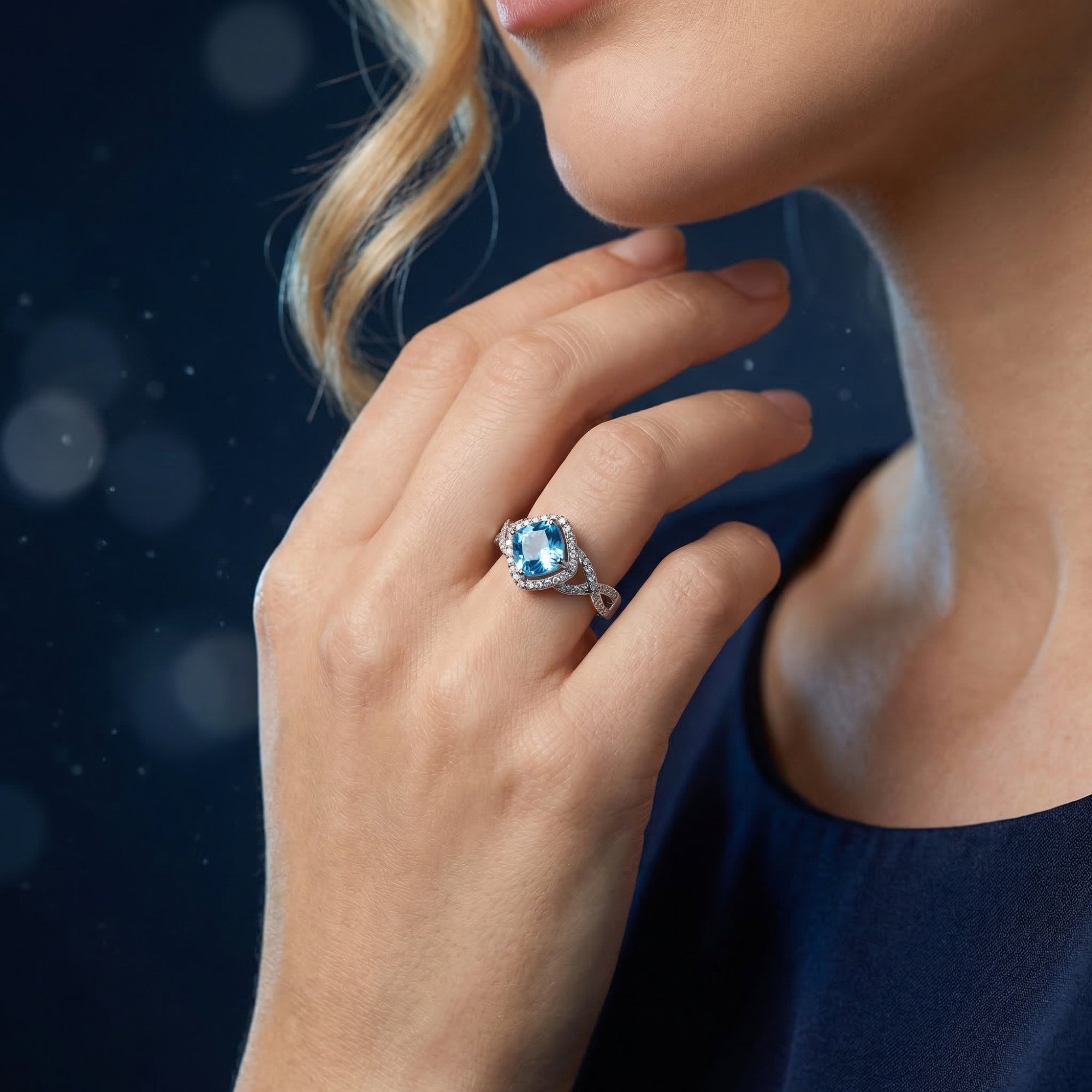 Woman wearing the cushion cut Swiss blue topaz sterling silver ring on her finger.