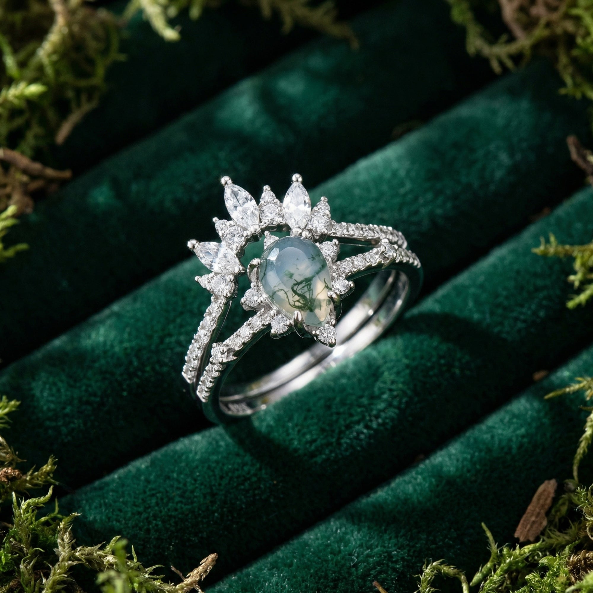 Detailed view of the frosted kite cut moss agate and marquise diamond ring set in a green velvet box.