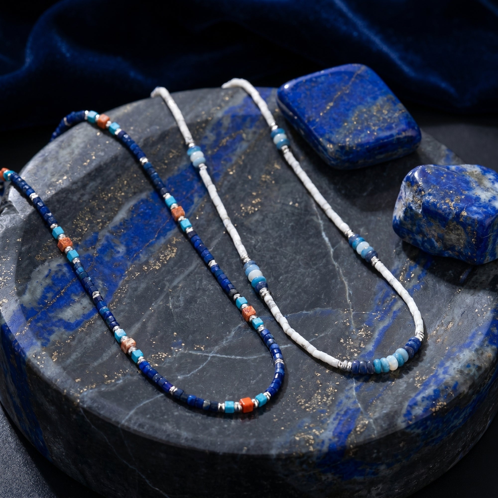 Two strands of the Altair natural lapis lazuli bead necklace with silver-toned spacers on a stone platter.