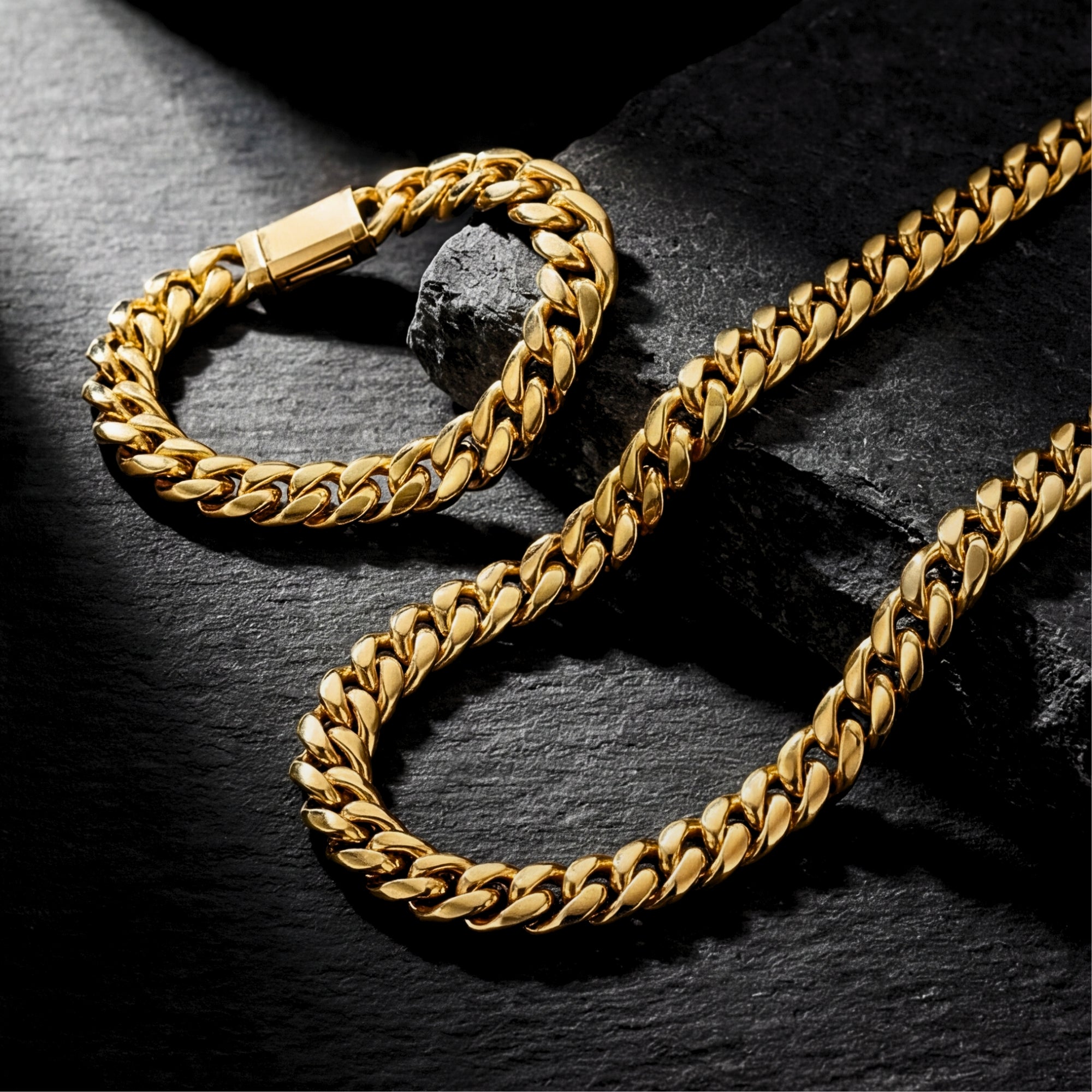 Detailed view of the 8mm gold stainless steel Cuban links and bracelet clasp on a textured dark surface.