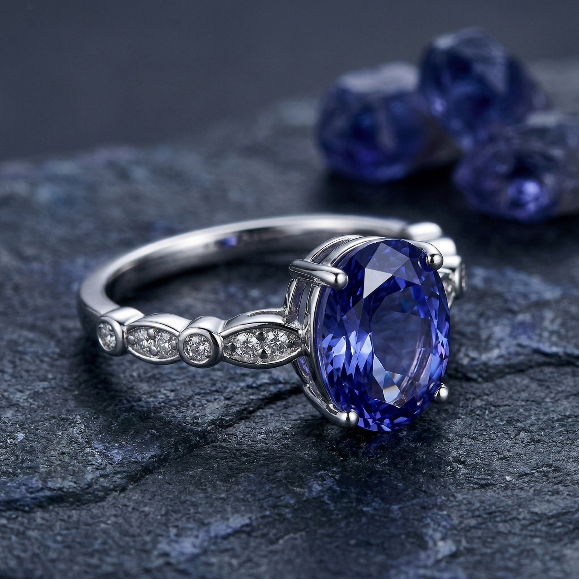 Side view of an oval tanzanite sterling silver ring showing the zircon-studded band and prong setting.