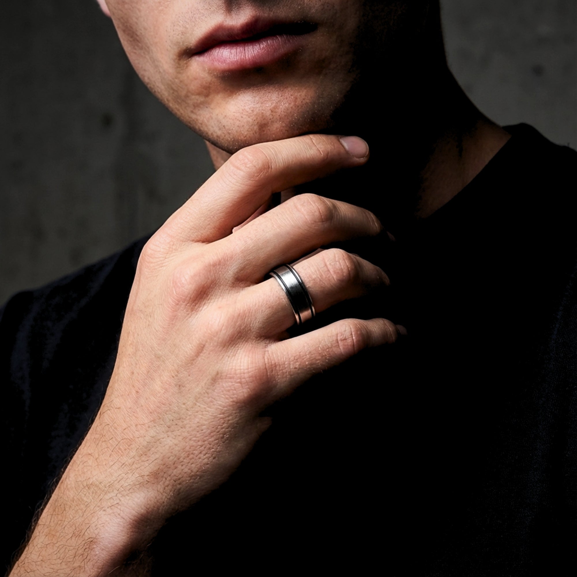 Men's silver stainless steel Horizon band ring worn on a finger, styled with a black t-shirt.