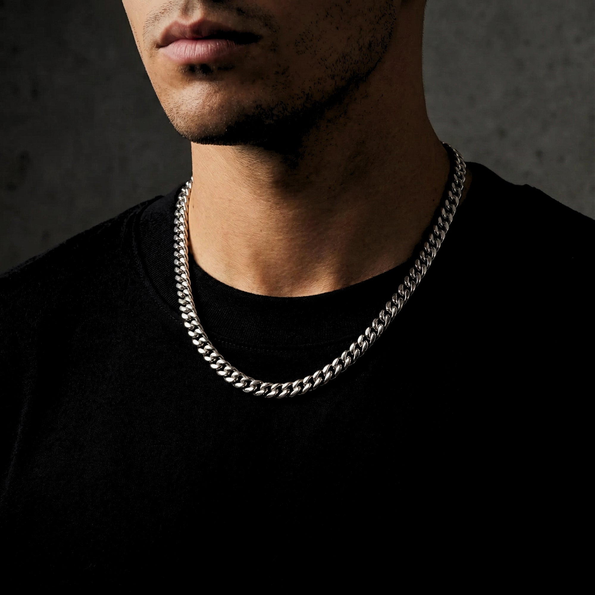 Front view of the 8mm silver stainless steel Cuban link chain worn by a man in a black t-shirt.