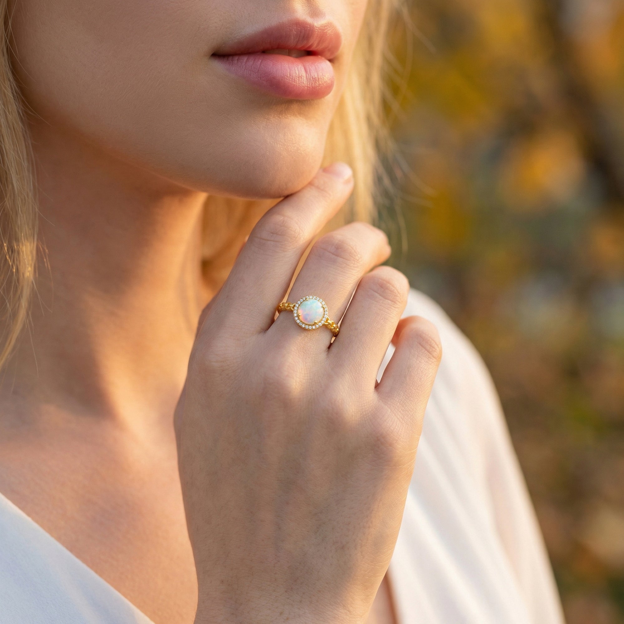 Gold-tone white opal statement ring worn by a model, showcasing its elegant scale and natural play-of-color.