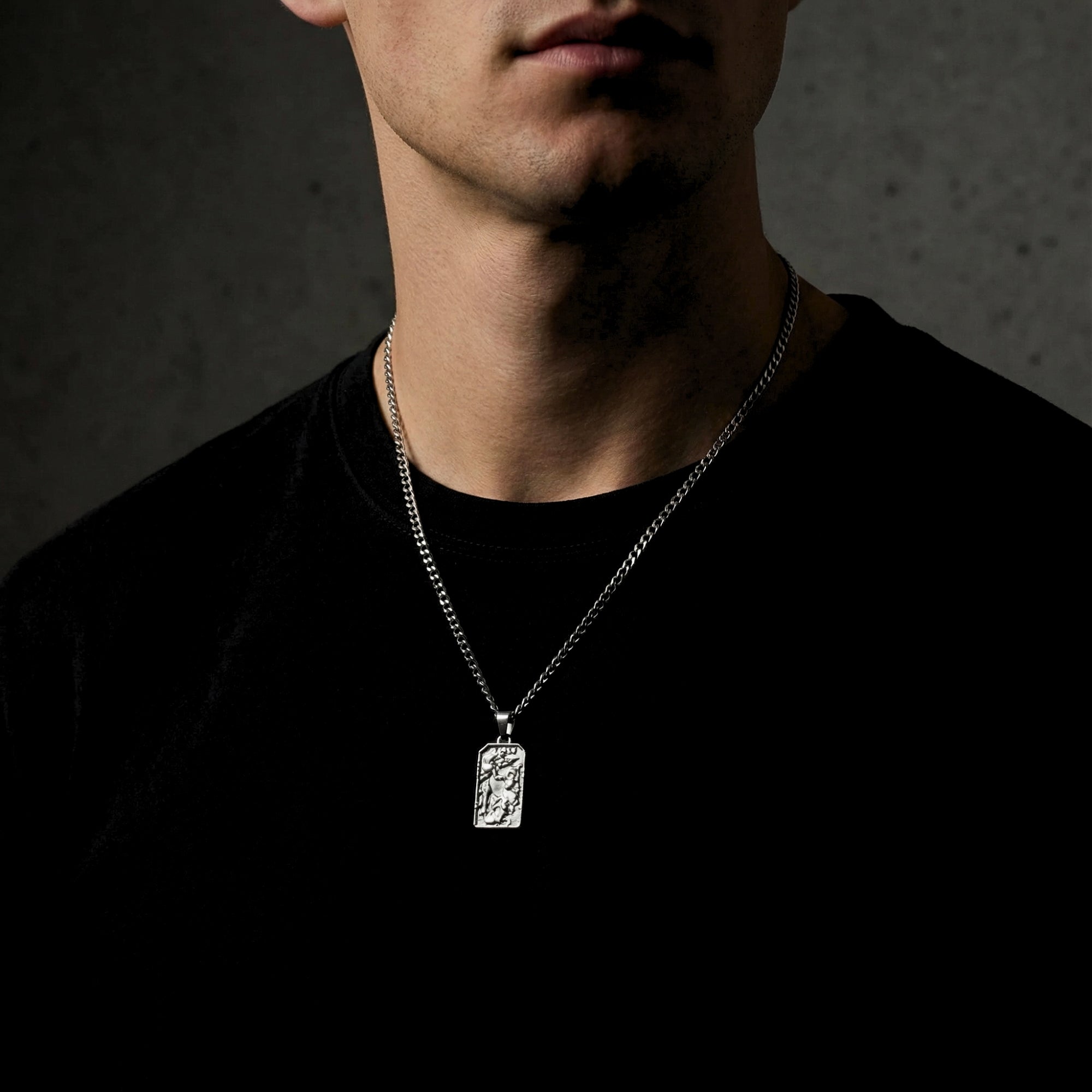 Silver St. Michael's Victory pendant necklace worn by a man, showing the pendant's size and how it hangs on the chest.