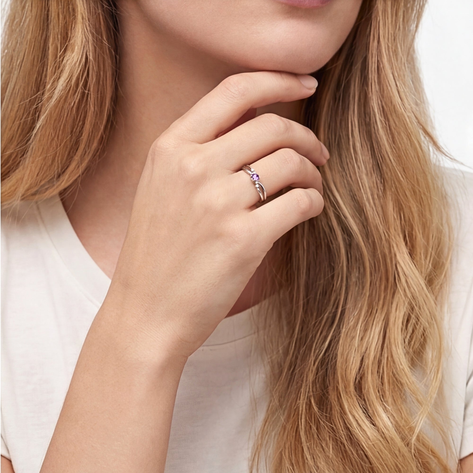 Close-up of the Astraea round simulated amethyst sterling silver ring worn on a woman's hand.
