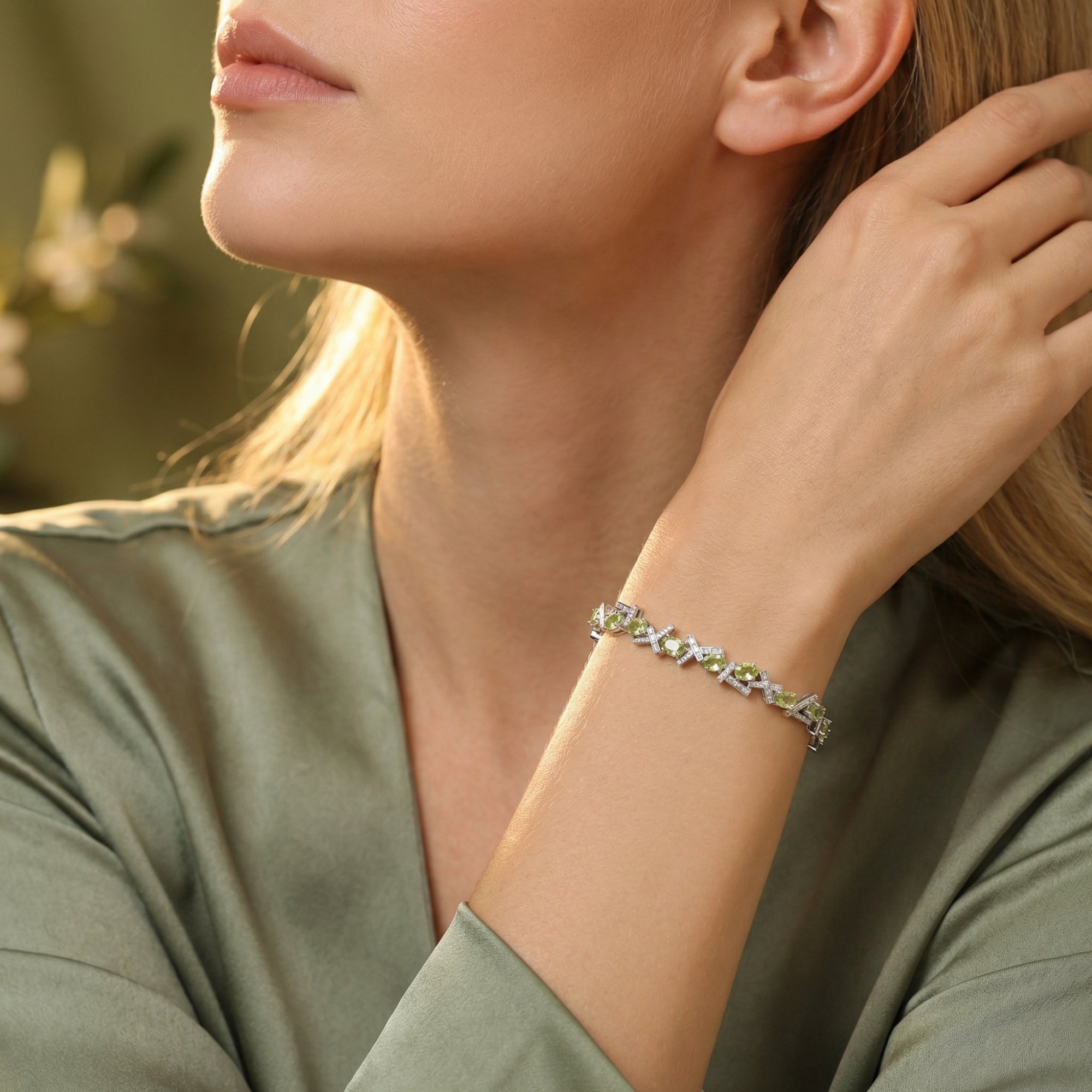 Sterling silver bracelet with oval cut green peridot stones worn by a model in a lifestyle setting.