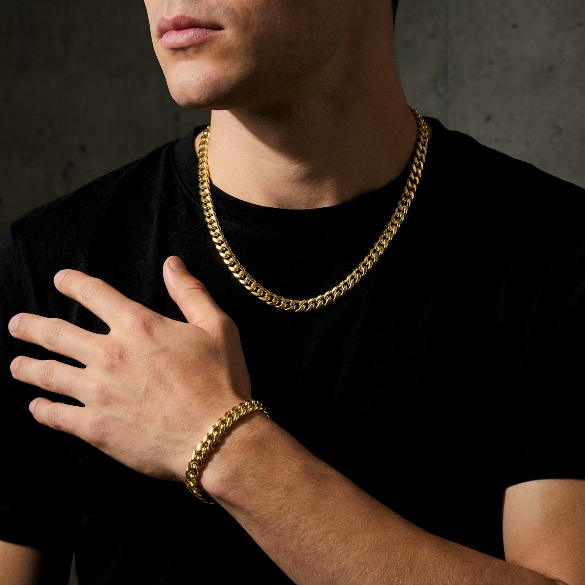 Gold stainless steel Cuban link set worn by a model, featuring an 8mm chain and matching bracelet.