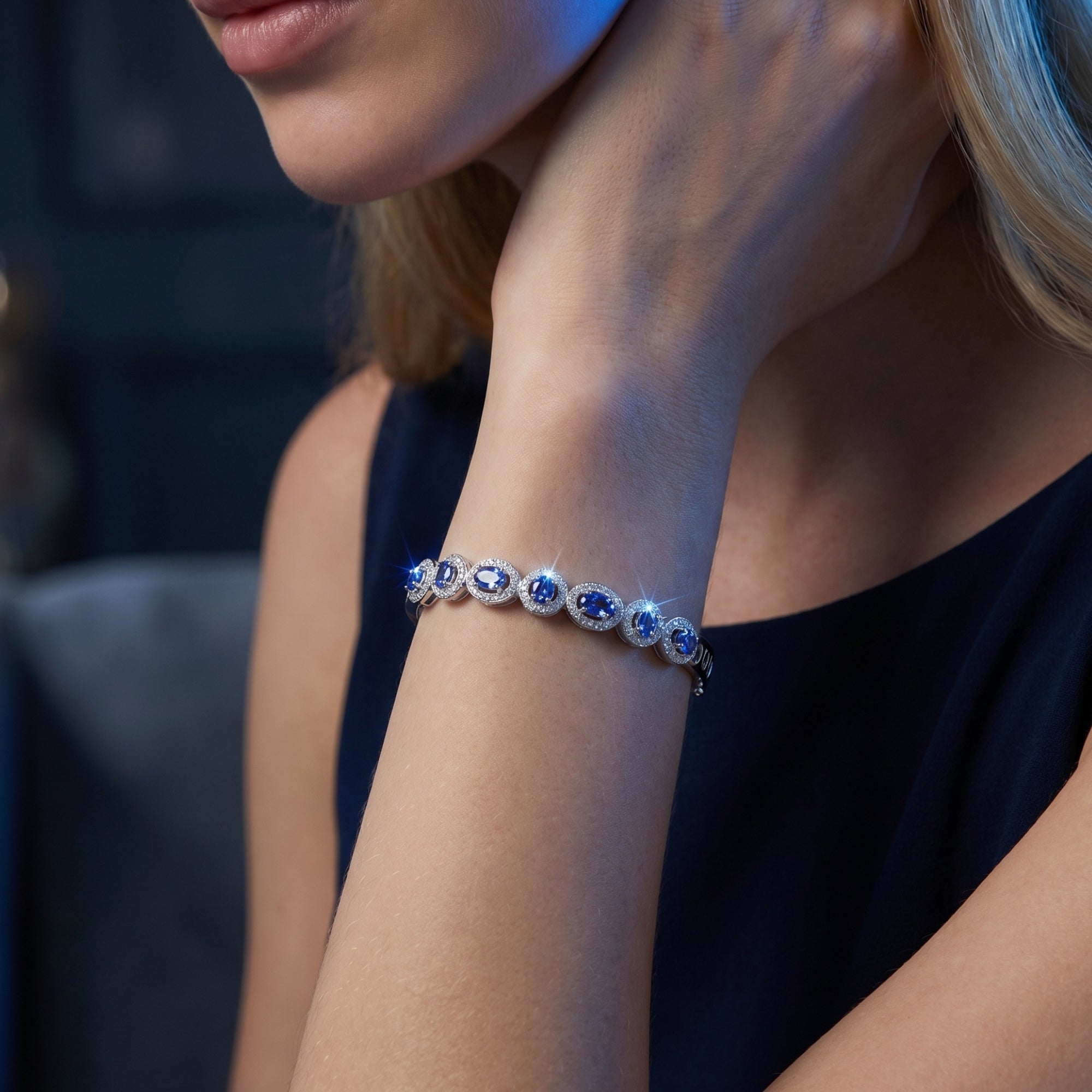 Close-up of a woman wearing the sterling silver tanzanite bracelet featuring sparkling oval and round cut stones.