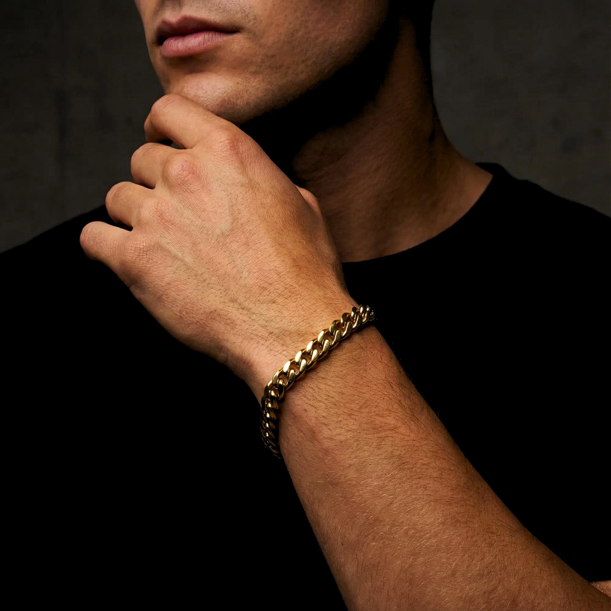 Man wearing an 8mm gold stainless steel Cuban link bracelet on his wrist.