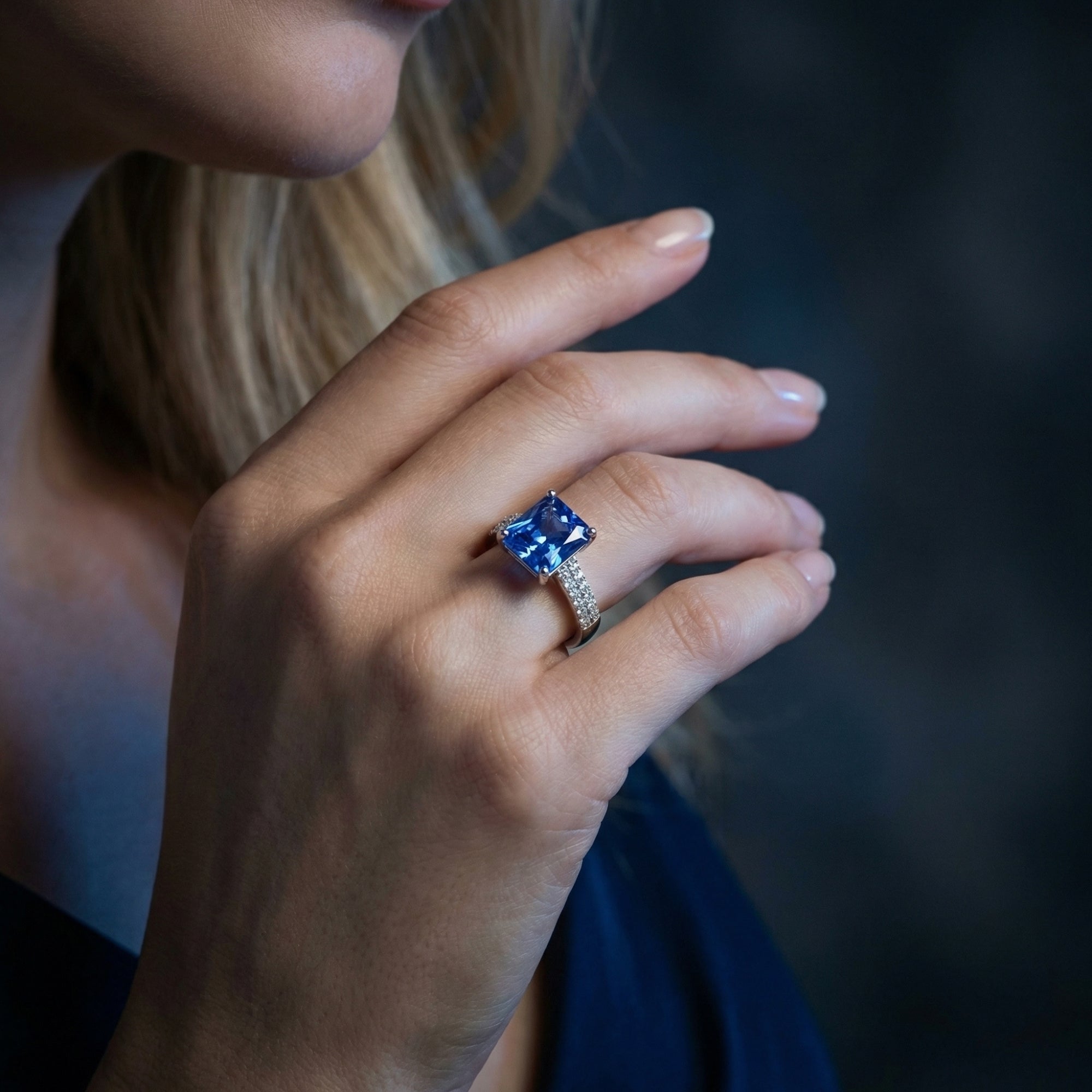 Side view of the Gwendolyn princess cut tanzanite and silver ring worn on a model's hand.