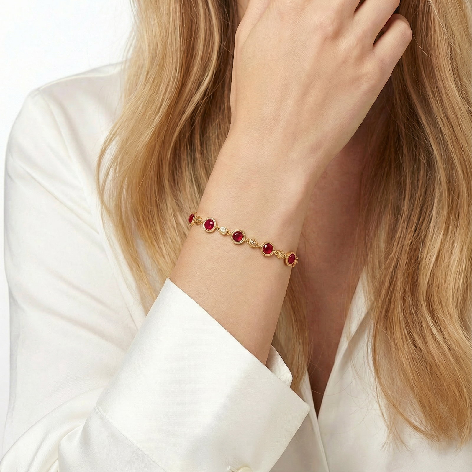 Model wearing the 18K gold vermeil Rosara station bracelet with round pigeon blood red simulated rubies.
