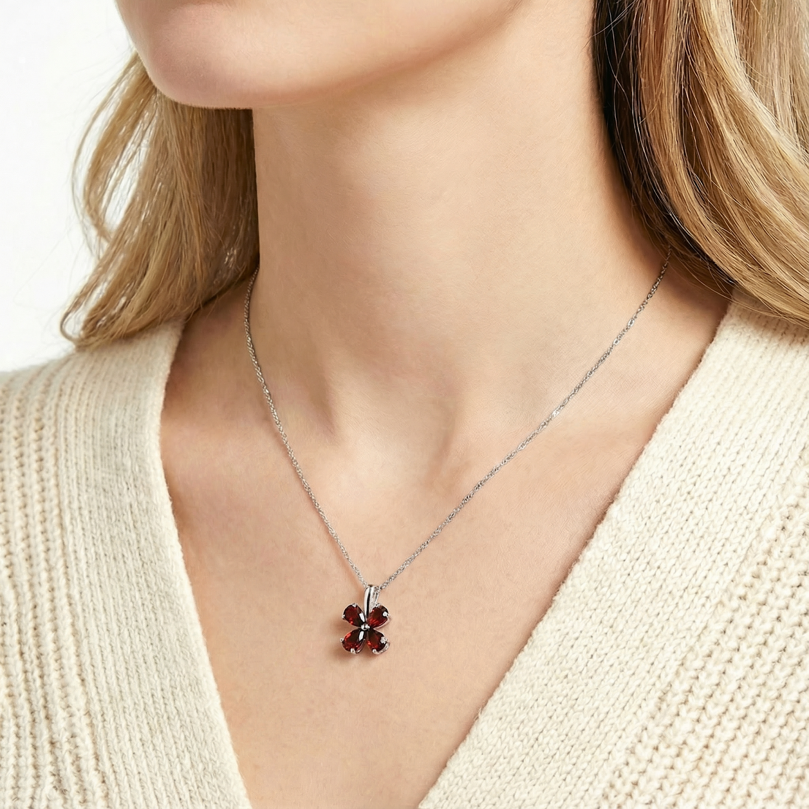 Model wearing the sterling silver Estara clover necklace with red simulated garnets on a silver chain.