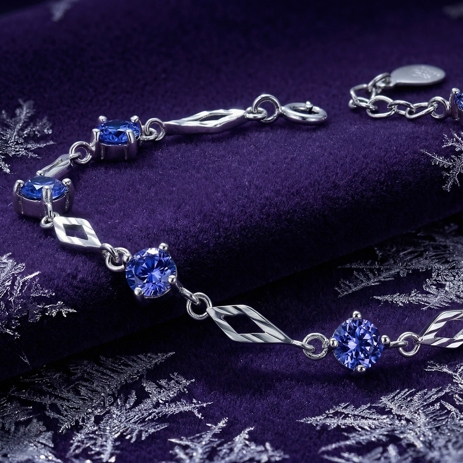 Macro view of a sterling silver station bracelet with round-cut blue-violet simulated tanzanite stones.
