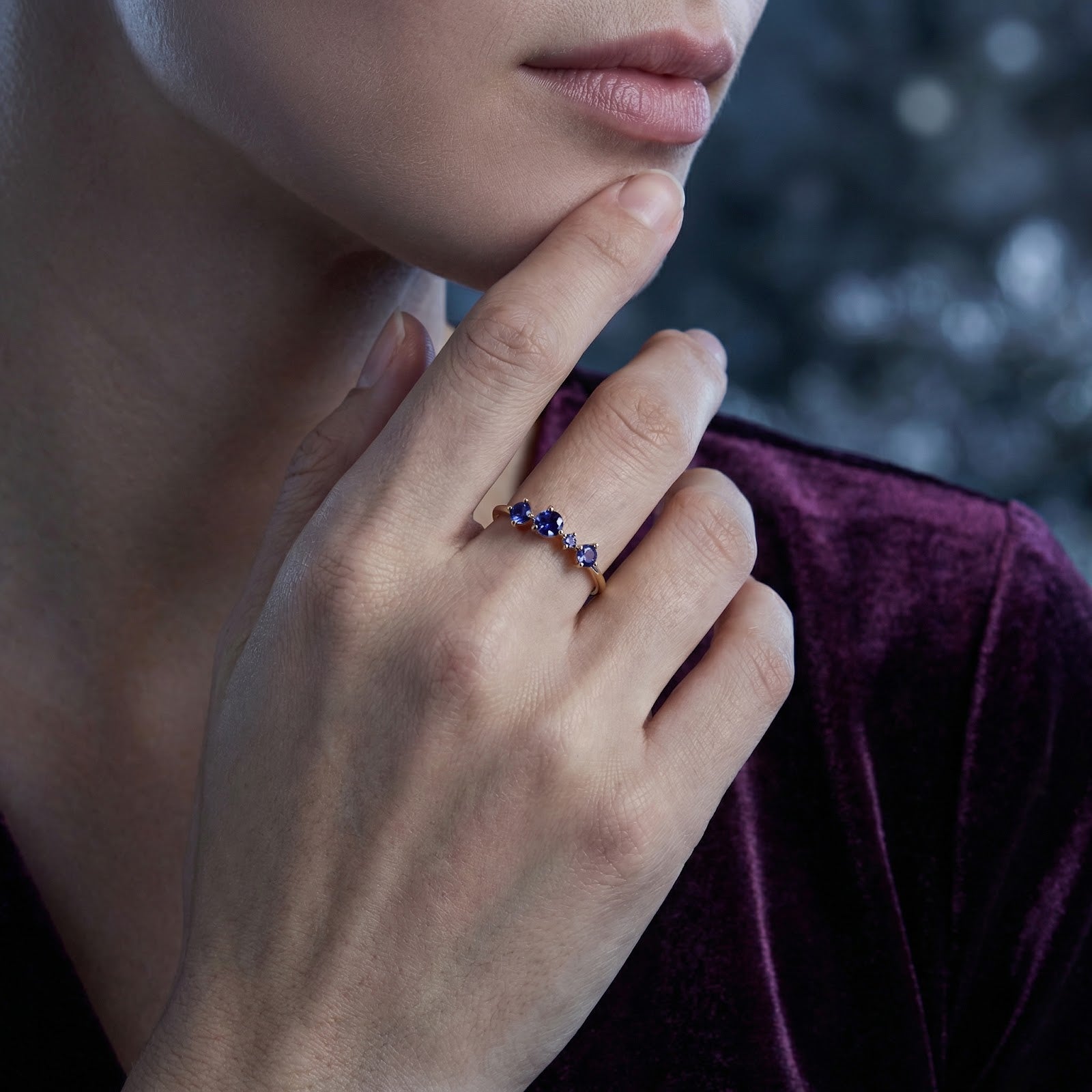 Close-up of the 18K gold vermeil cascade ring with blue simulated tanzanite stones worn on a model's hand.