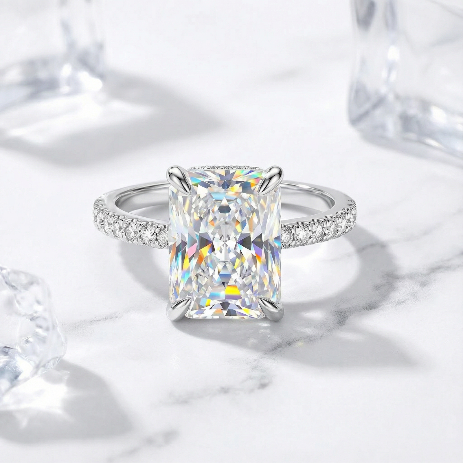 Radiant cut simulated diamond ring in S925 sterling silver on a marble surface with ice cubes.