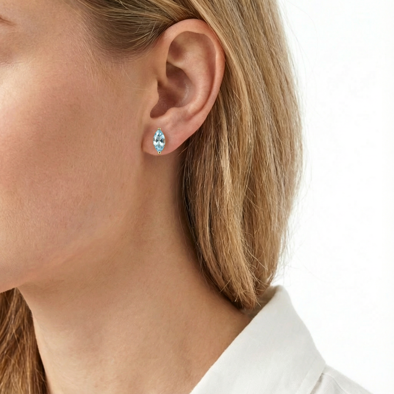 Marquise cut simulated aquamarine earring in 18K gold vermeil worn on a model's ear.