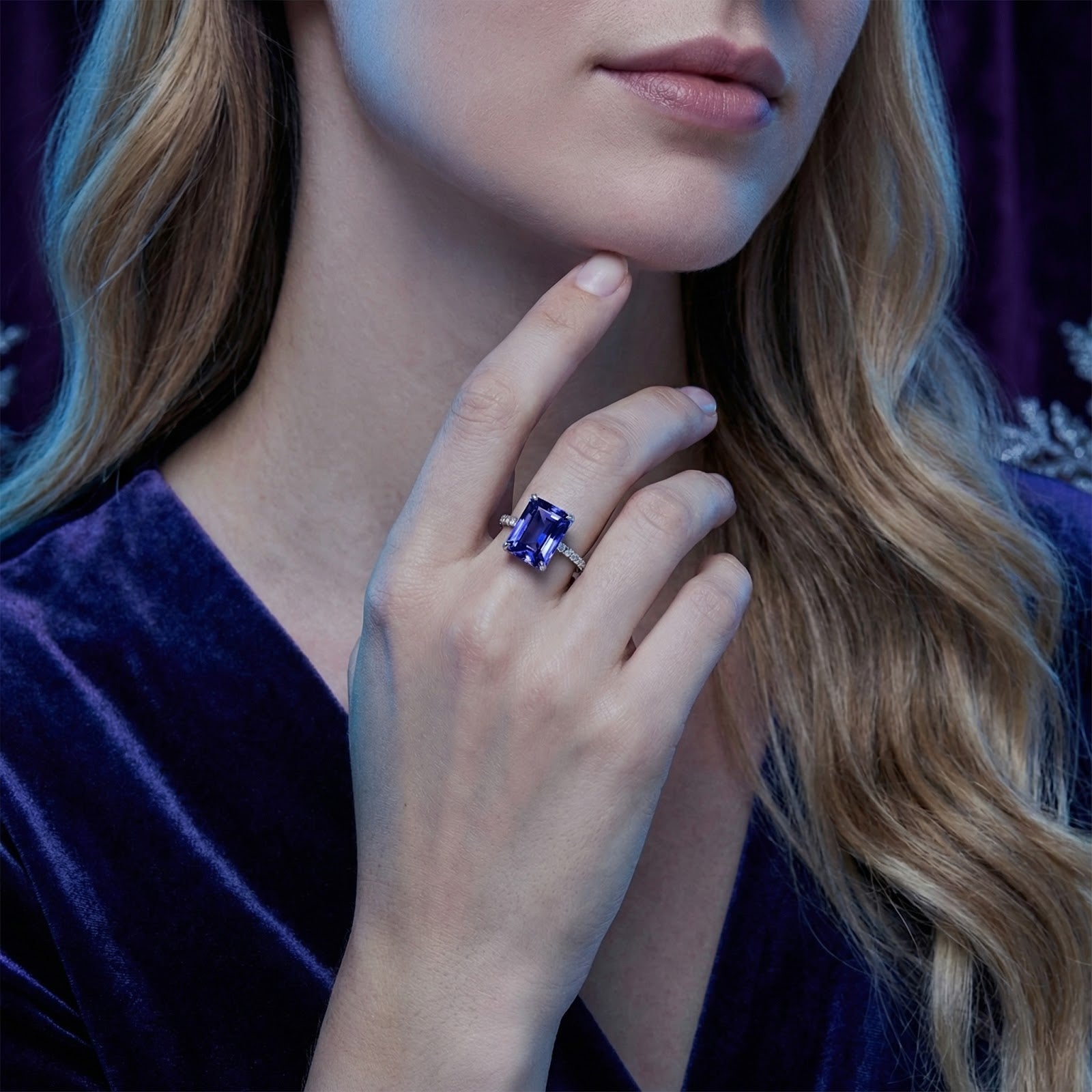 Model wearing the radiant cut simulated tanzanite sterling silver ring with a purple velvet dress.
