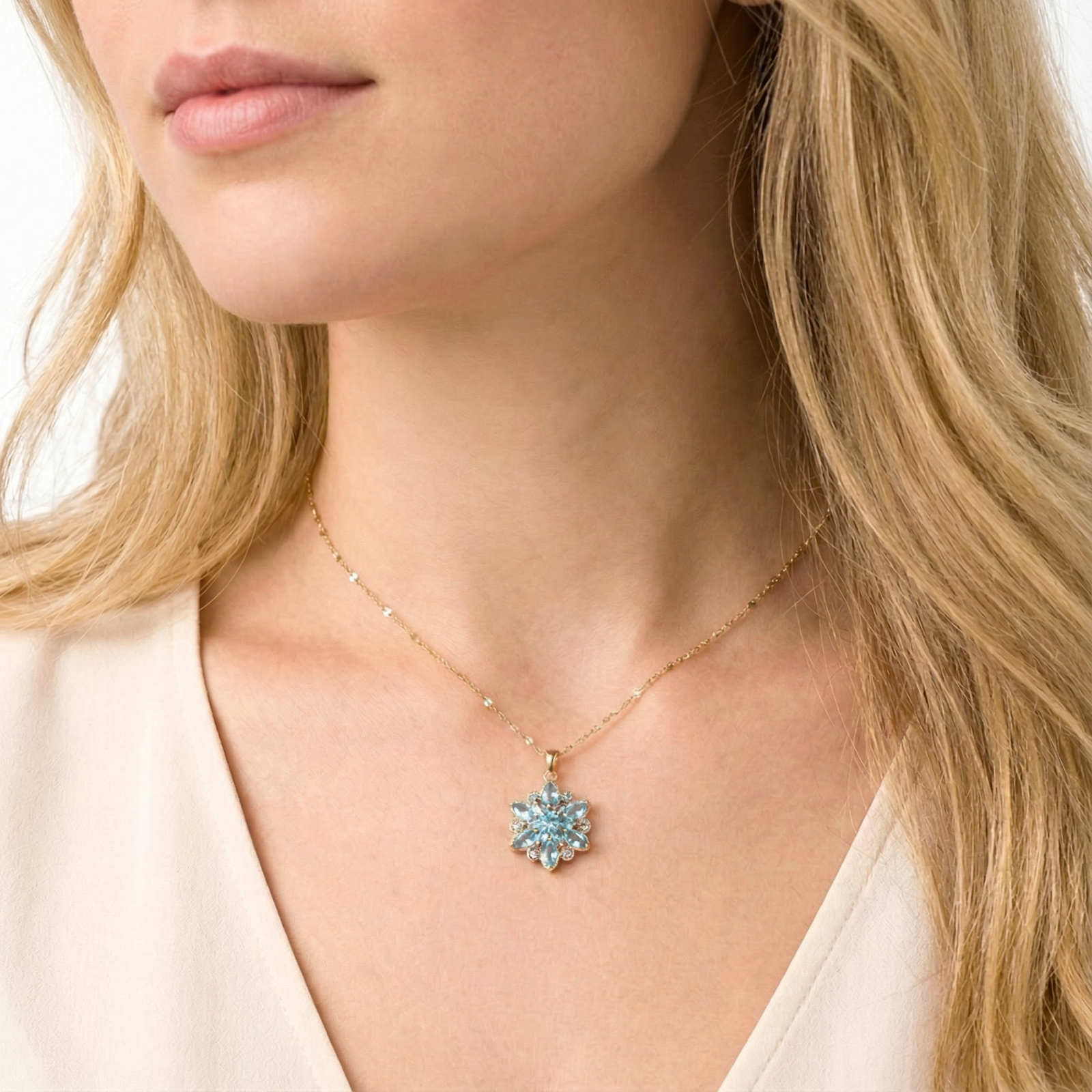 Close-up of a model wearing the gold stainless steel Kaelia Bloom necklace with a blue aquamarine flower pendant.