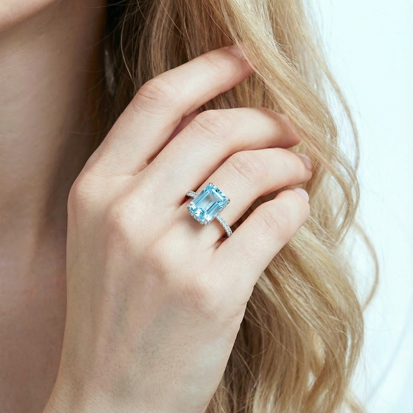 Radiant-cut simulated aquamarine sterling silver ring shown on a model's hand.