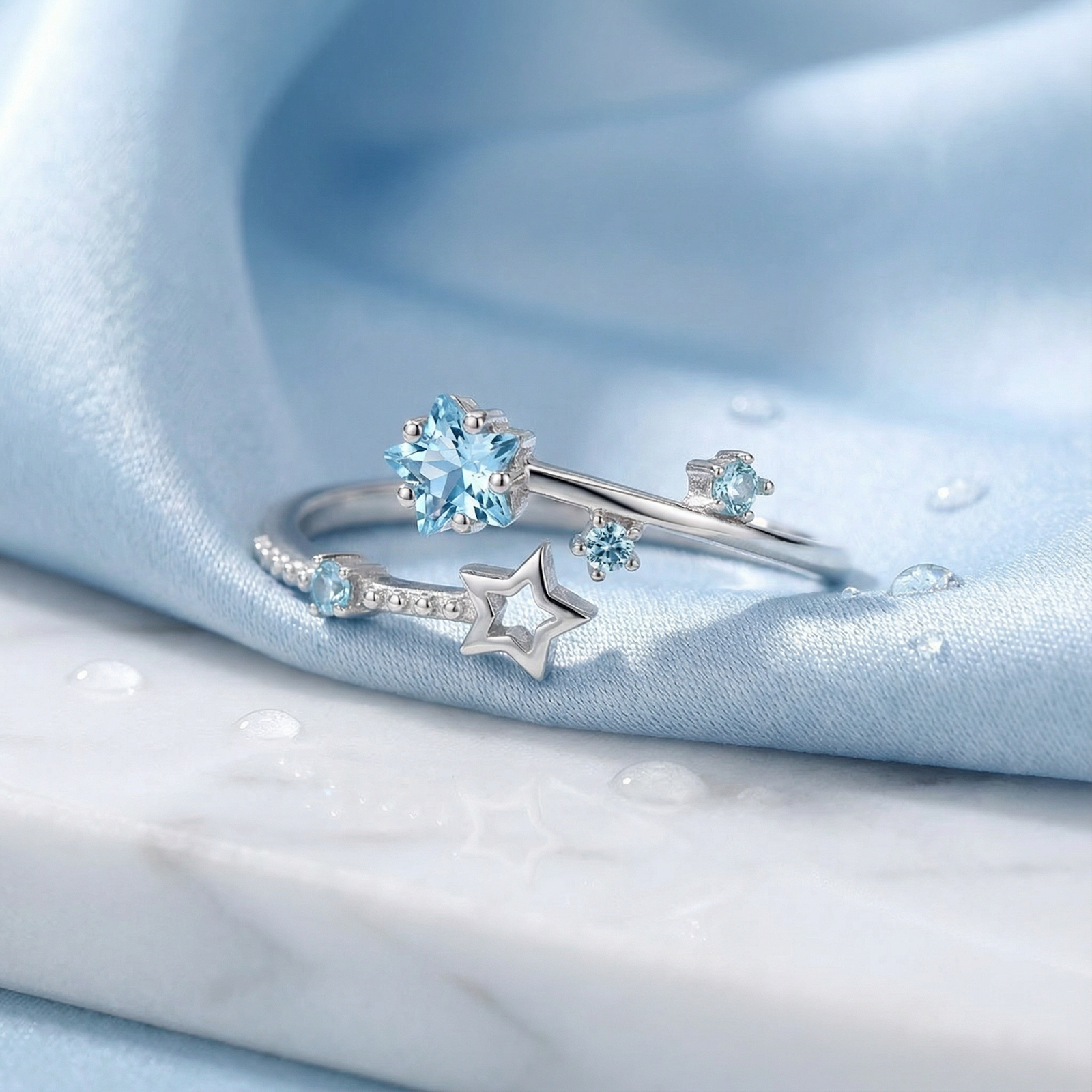 Macro view of star-cut simulated aquamarine stones on the S925 sterling silver Stella bypass ring.