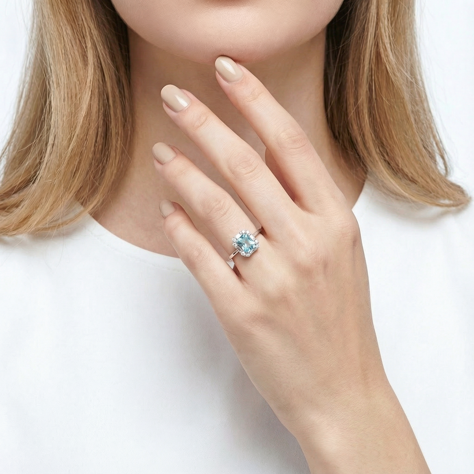 Model wearing the Linnea octagon cut simulated aquamarine halo ring in sterling silver on her ring finger.