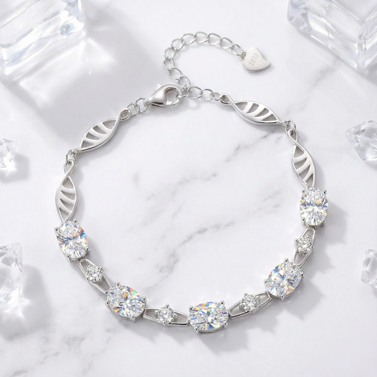 Lysithea silver bracelet with oval and round simulated diamonds on a marble surface with ice props.