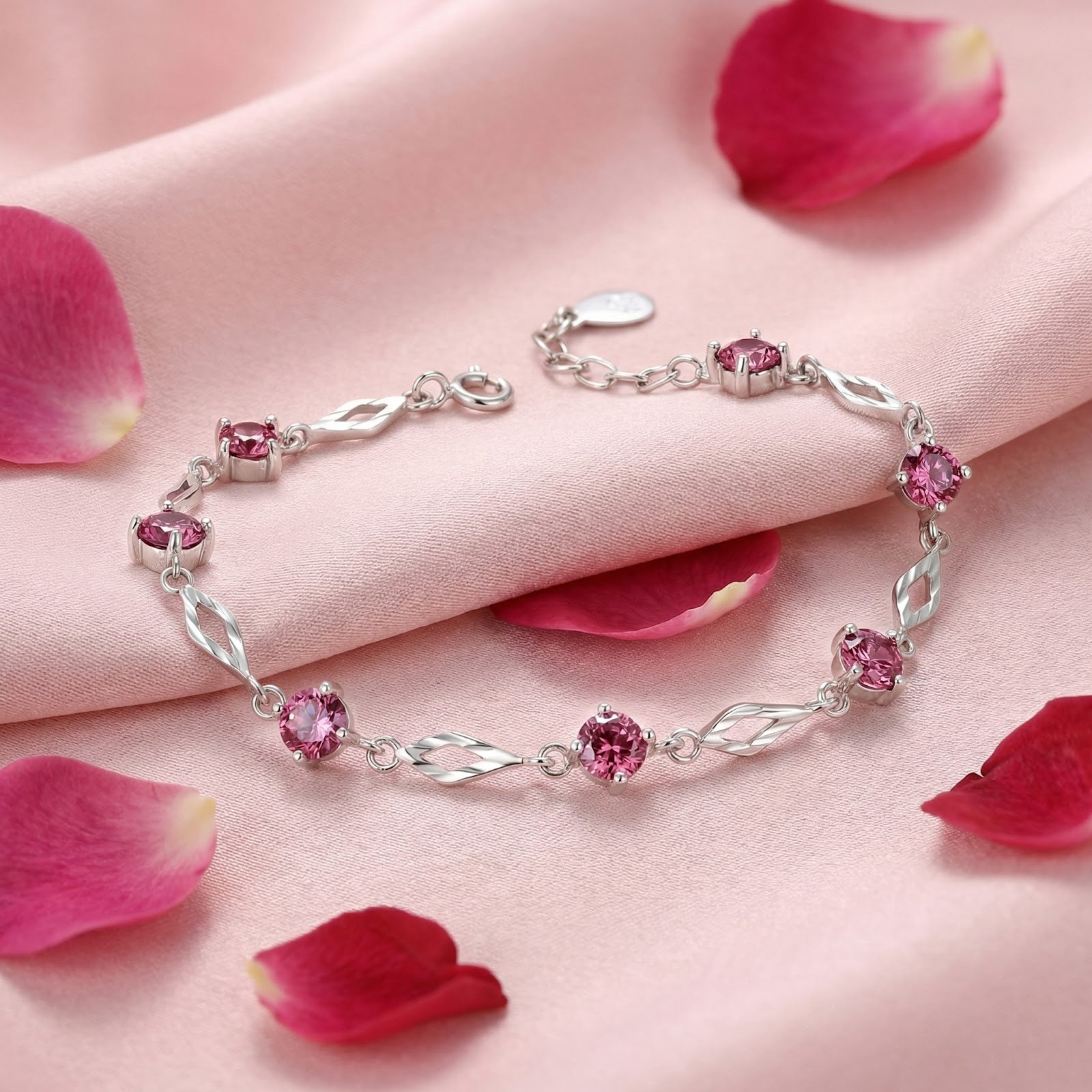 S925 sterling silver station bracelet with round pink tourmaline stones on pink silk with rose petals.