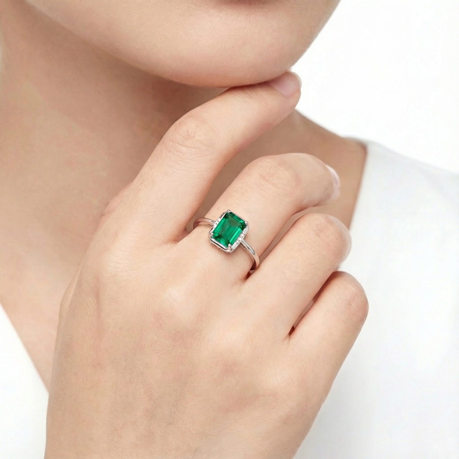 Woman wearing the emerald-cut simulated emerald sterling silver ring on her finger.