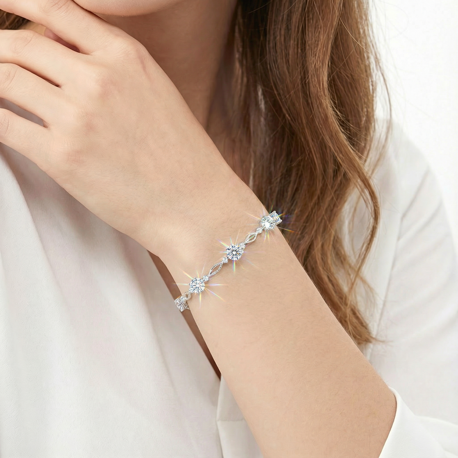 Sterling silver Aetheris station bracelet with sparkling round cut simulated diamonds worn on a woman's wrist.
