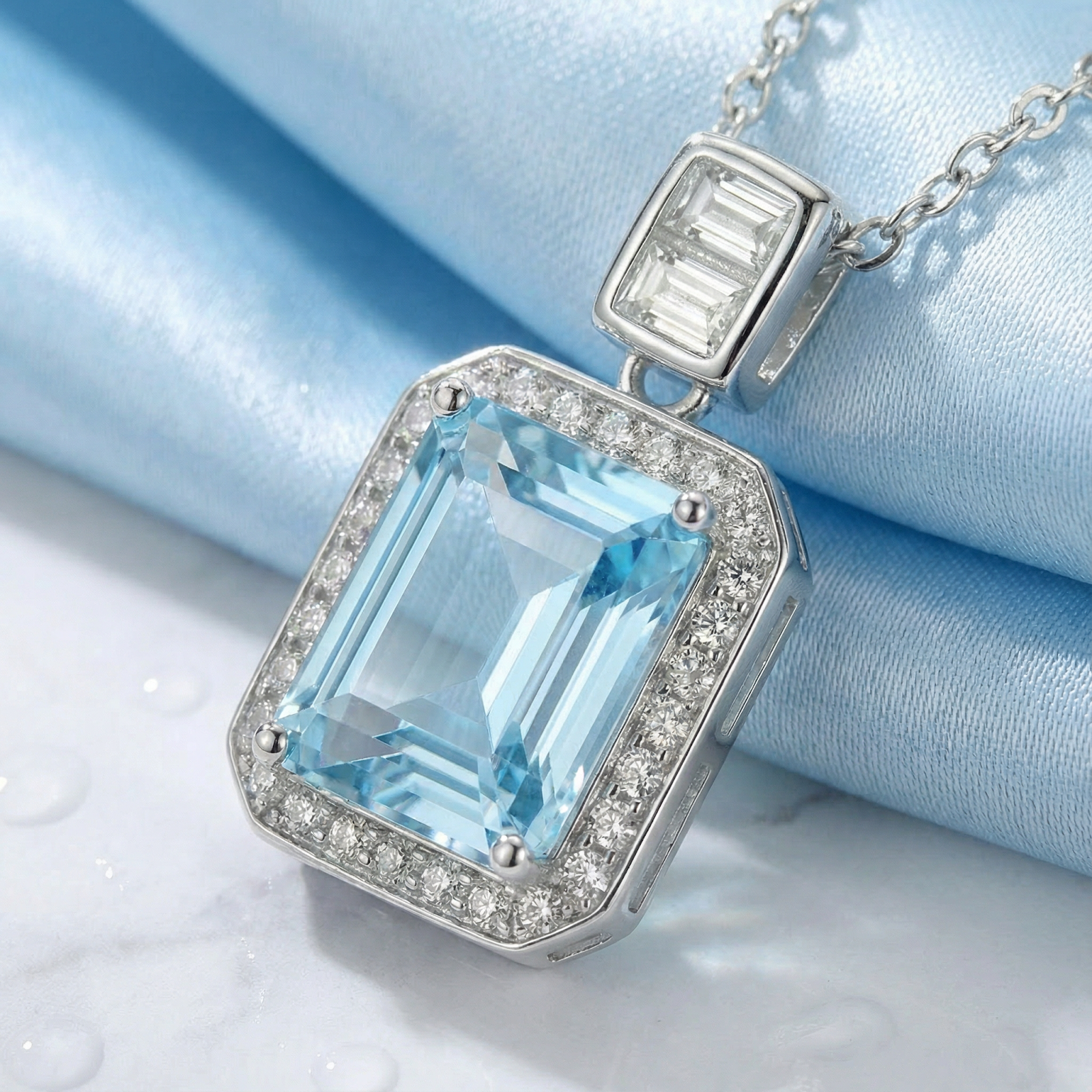 Macro view of an emerald-cut simulated aquamarine pendant with baguette accents in sterling silver.