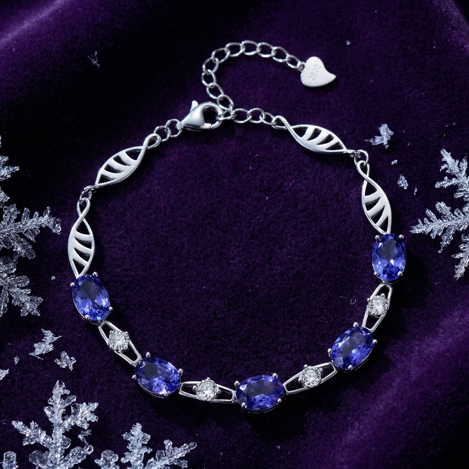 Sterling silver station bracelet with oval simulated tanzanite on purple velvet with snowflakes.