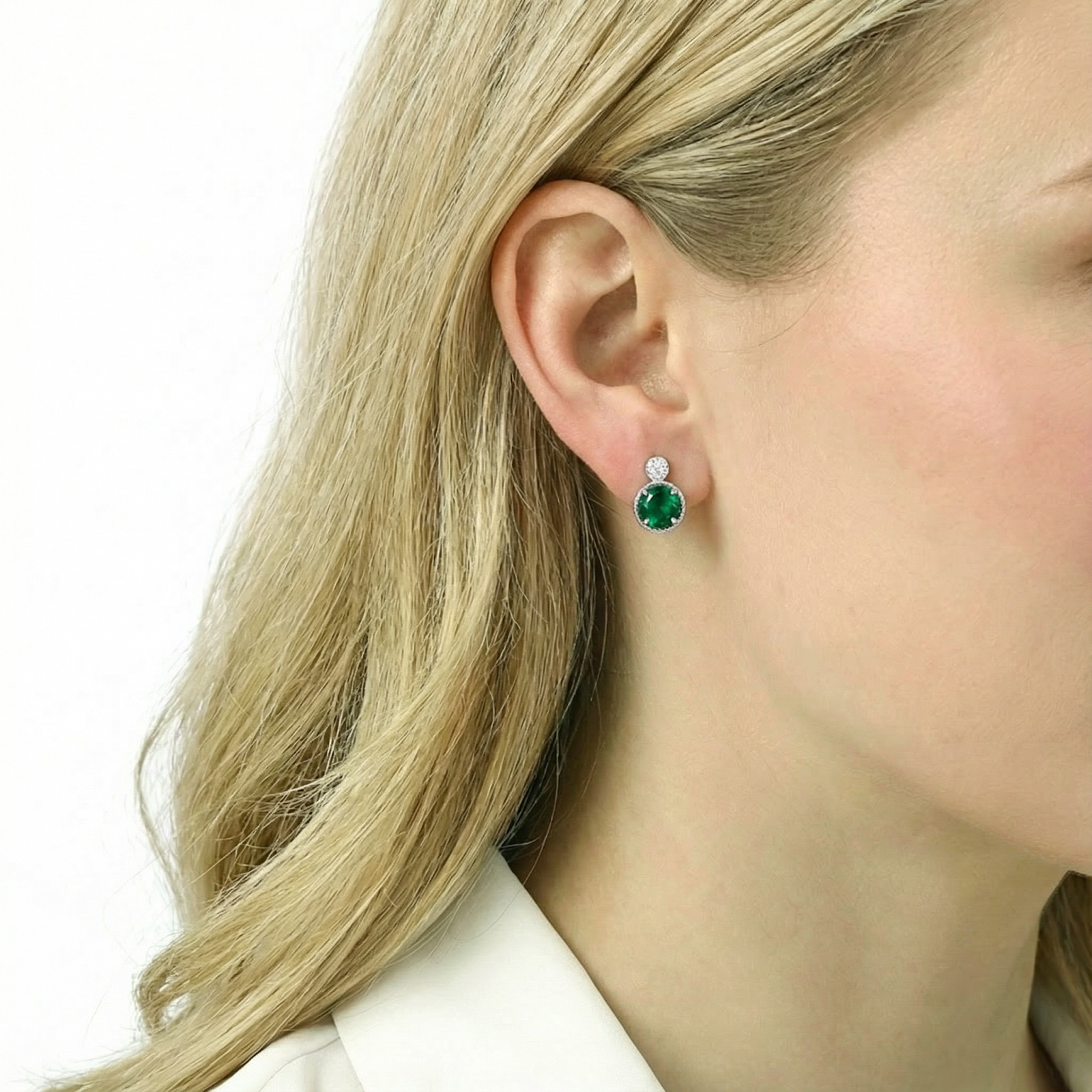 Blonde model wearing a round-cut simulated emerald halo stud earring in S925 sterling silver.