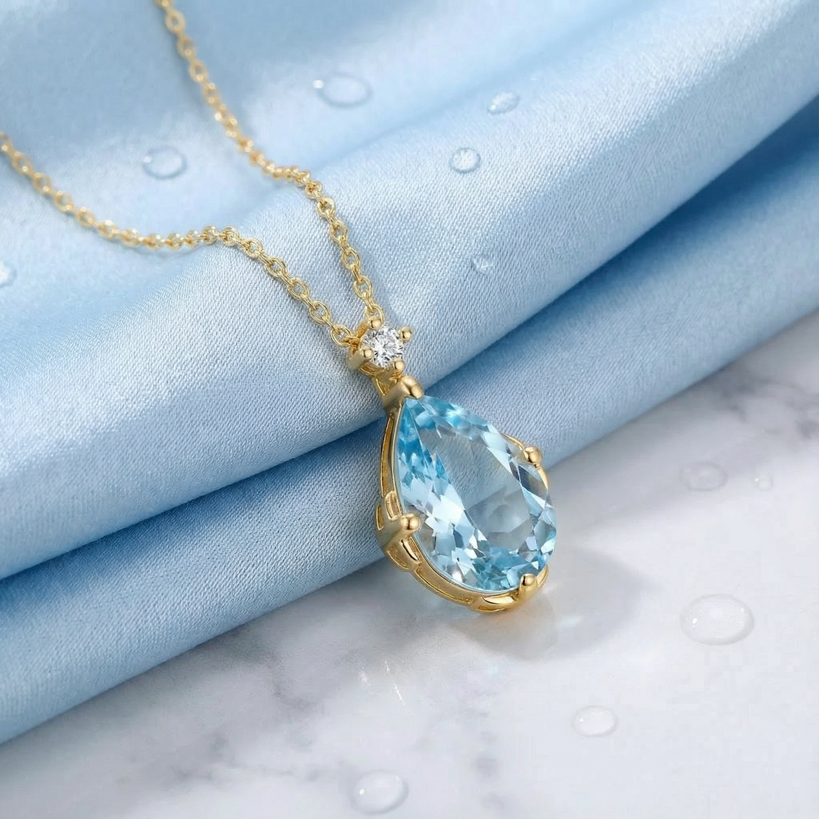 Macro view of a pear cut light blue simulated aquamarine pendant in an 18K gold vermeil setting.
