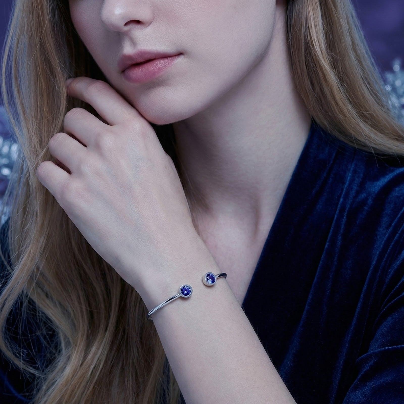 Model wearing the silver stainless steel Veralis cuff with round blue simulated tanzanite stones on her wrist.