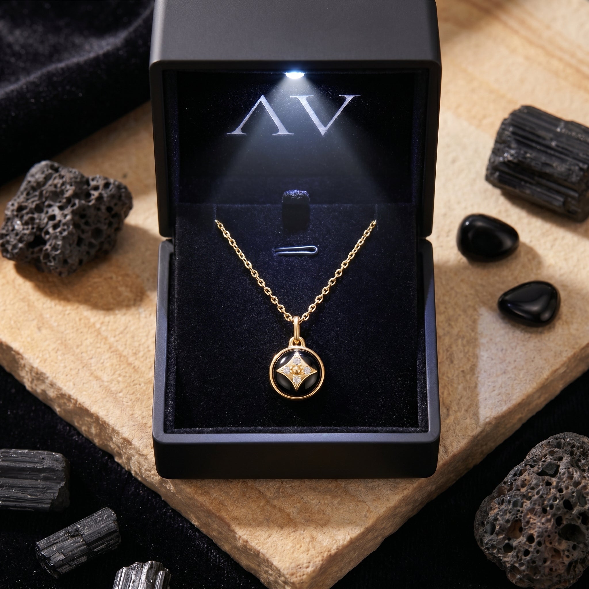 Gold plated natural onyx pendant necklace inside a black branded jewelry box with an integrated LED light.