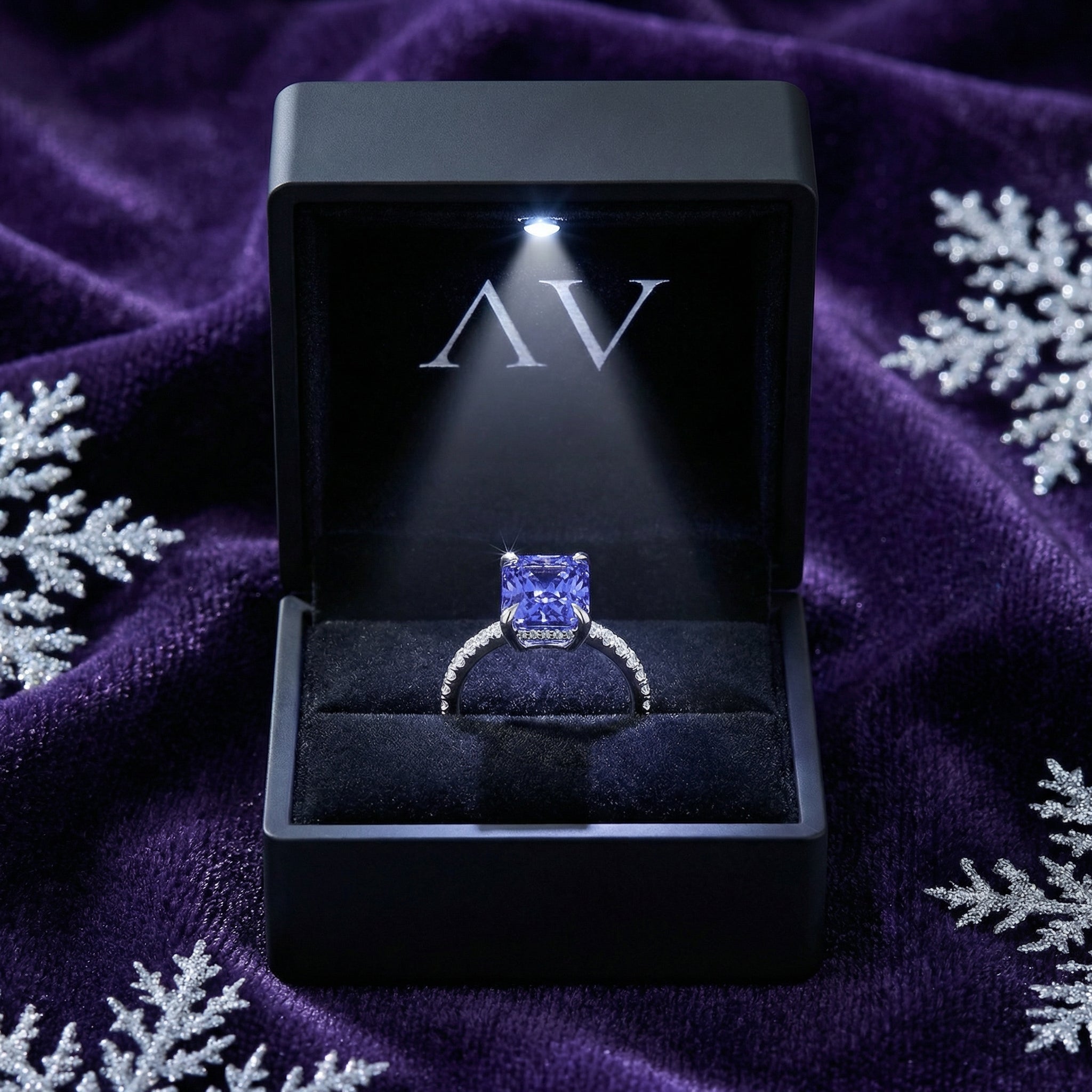Radiant cut simulated tanzanite sterling silver ring in a lighted black AV jewelry box on purple velvet.