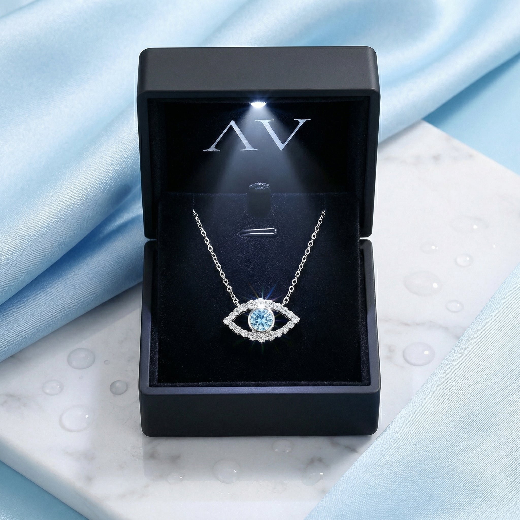 The Elara Eye sterling silver necklace displayed in a black LED-lit jewelry presentation box.