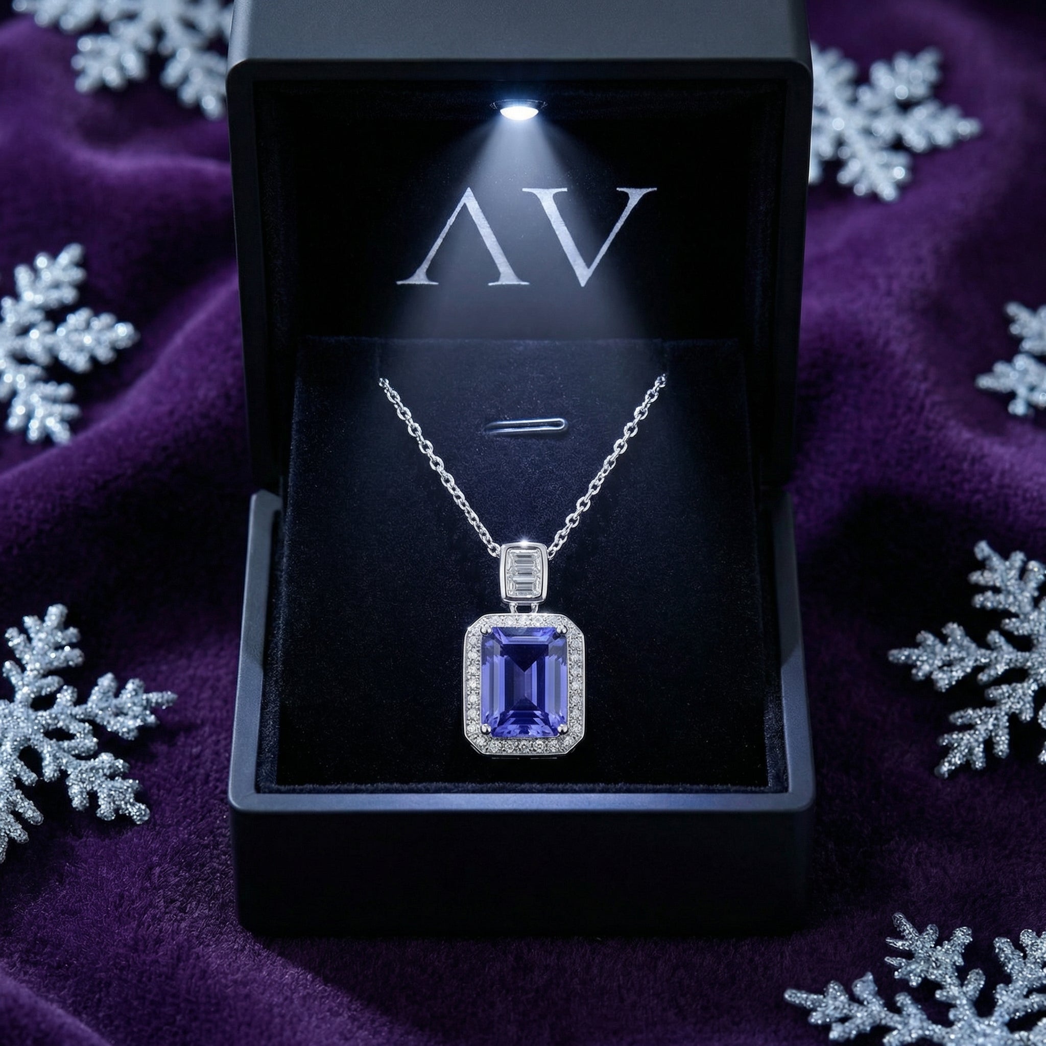 Emerald-cut simulated tanzanite silver necklace in a lighted black jewelry gift box on purple velvet with snowflakes.