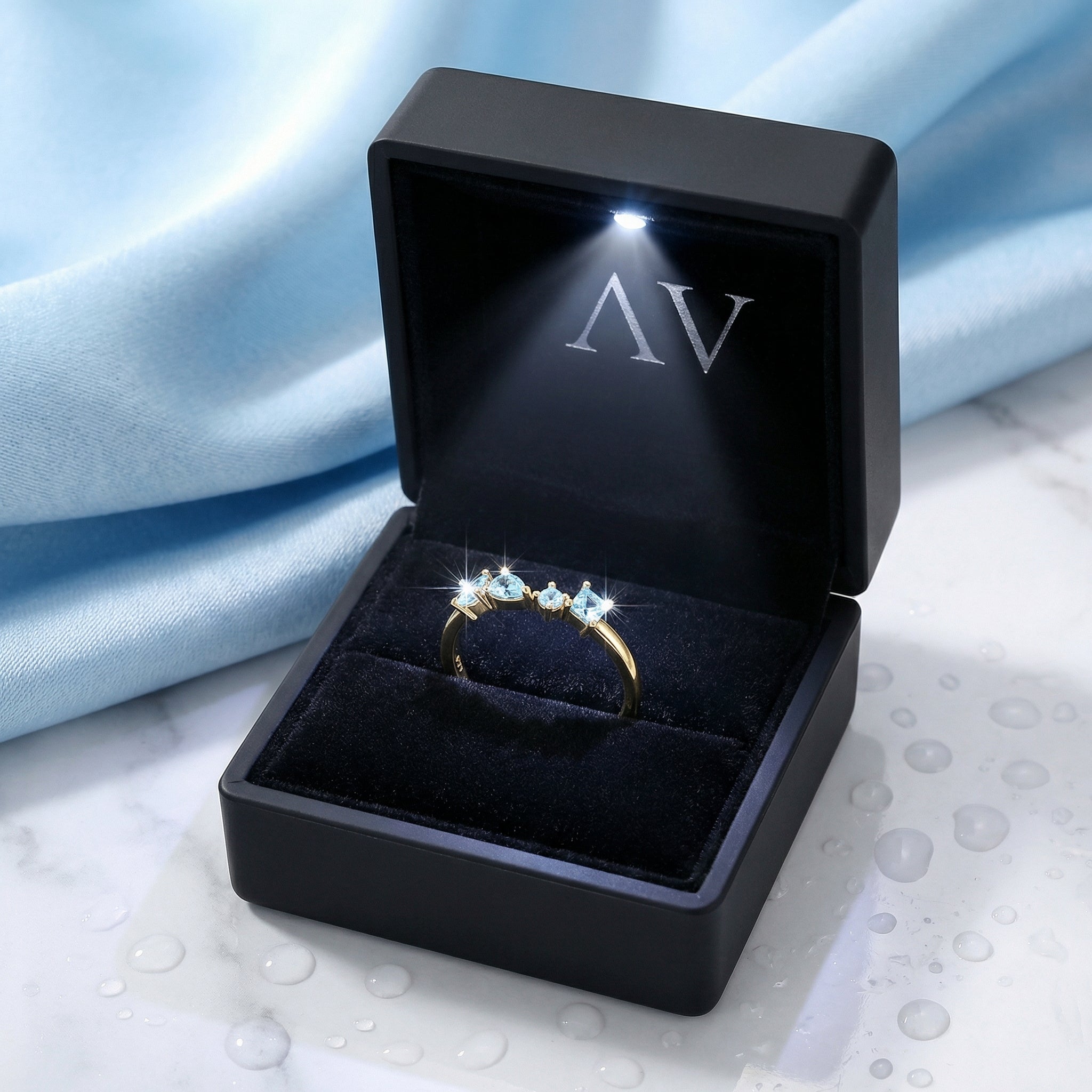 18K gold vermeil simulated aquamarine cluster ring inside a black LED-lit jewelry presentation box.